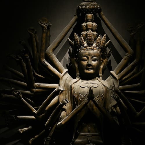 Bronze statue of the thousand-armed Guanyin, hands raised in a fan of gestures
